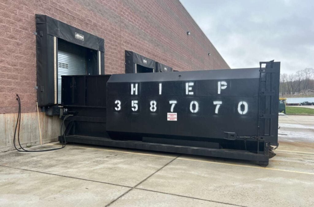 A large, green Hiep Sanitation dumpster being used during a commercial renovation project in Bergen County, NJ, illustrating the company's capacity for handling substantial waste management needs.