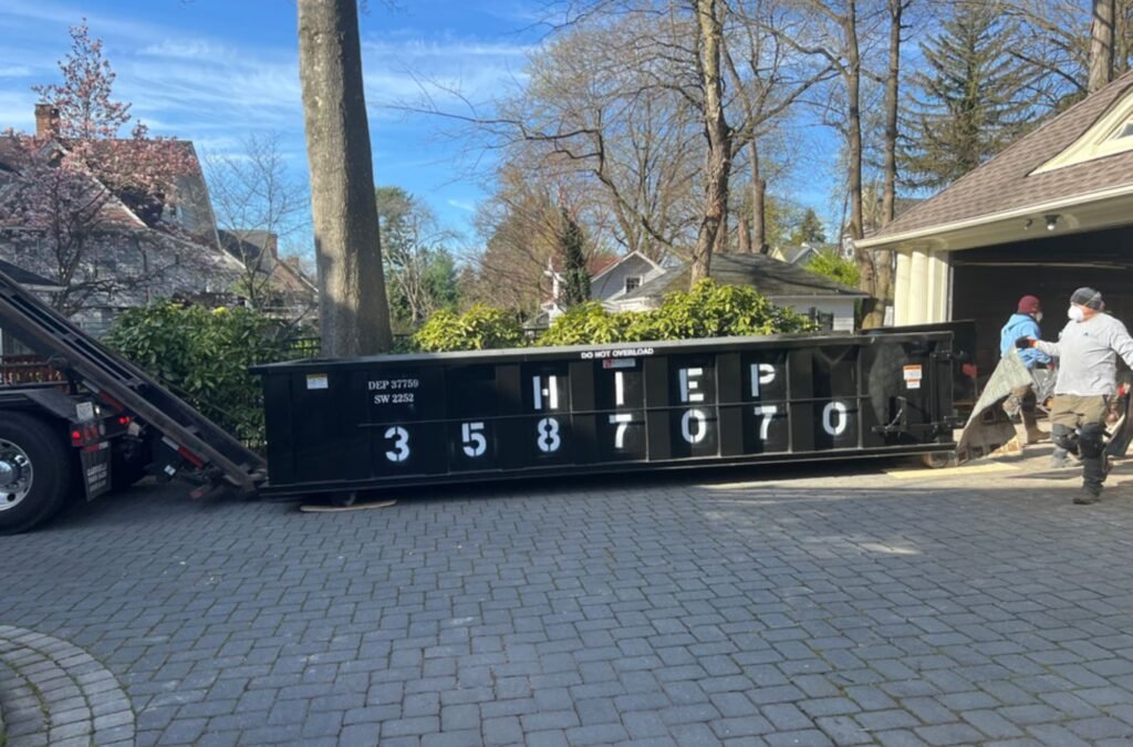 A professional team assisting with dumpster rental setup in Scarsdale, NY, ensuring smooth waste disposal for residential and commercial projects.